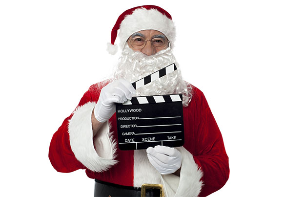 Cheerful Aged Santa Posing With A Clapperboard